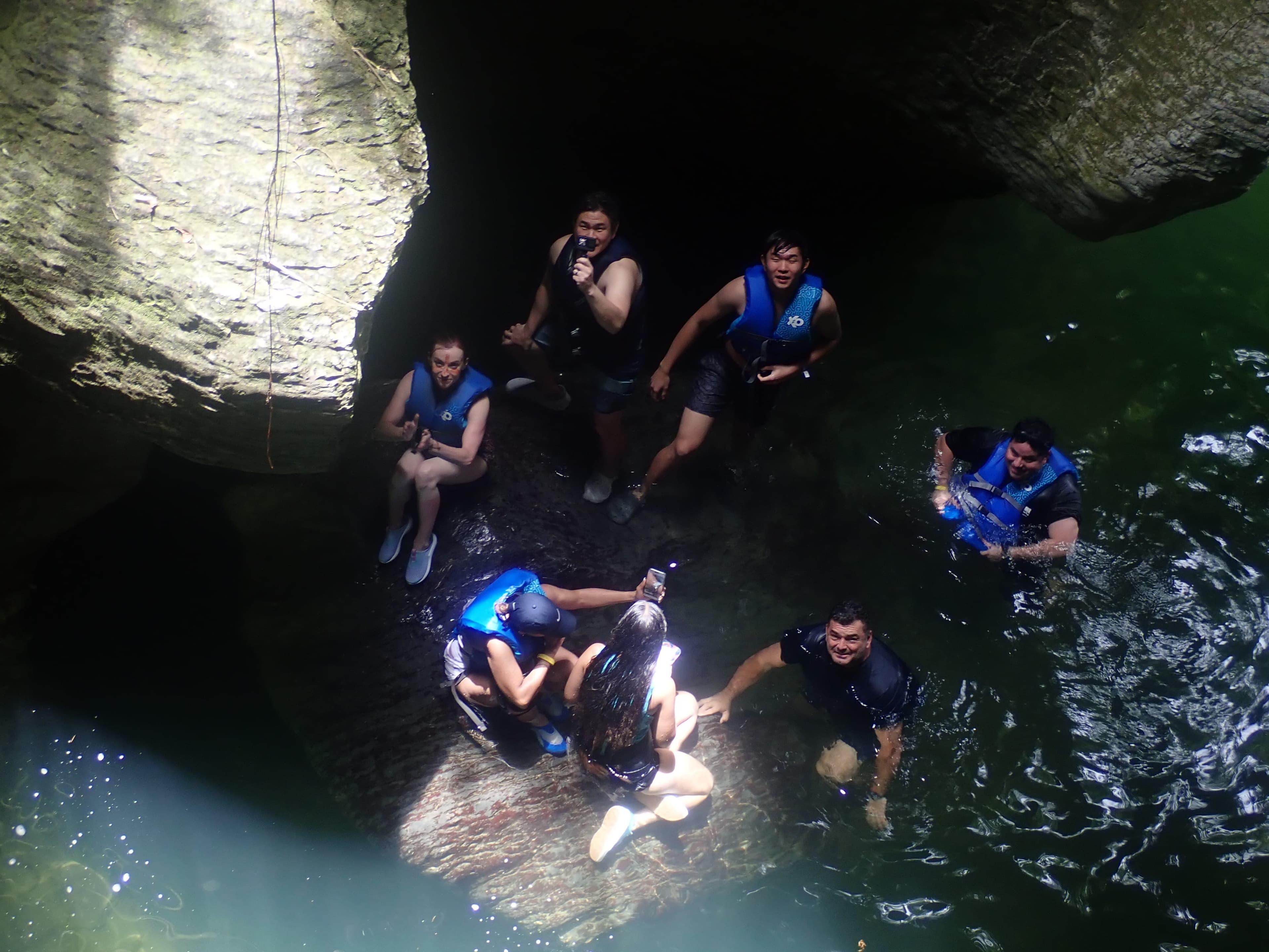 Group swimming in a cave river pool