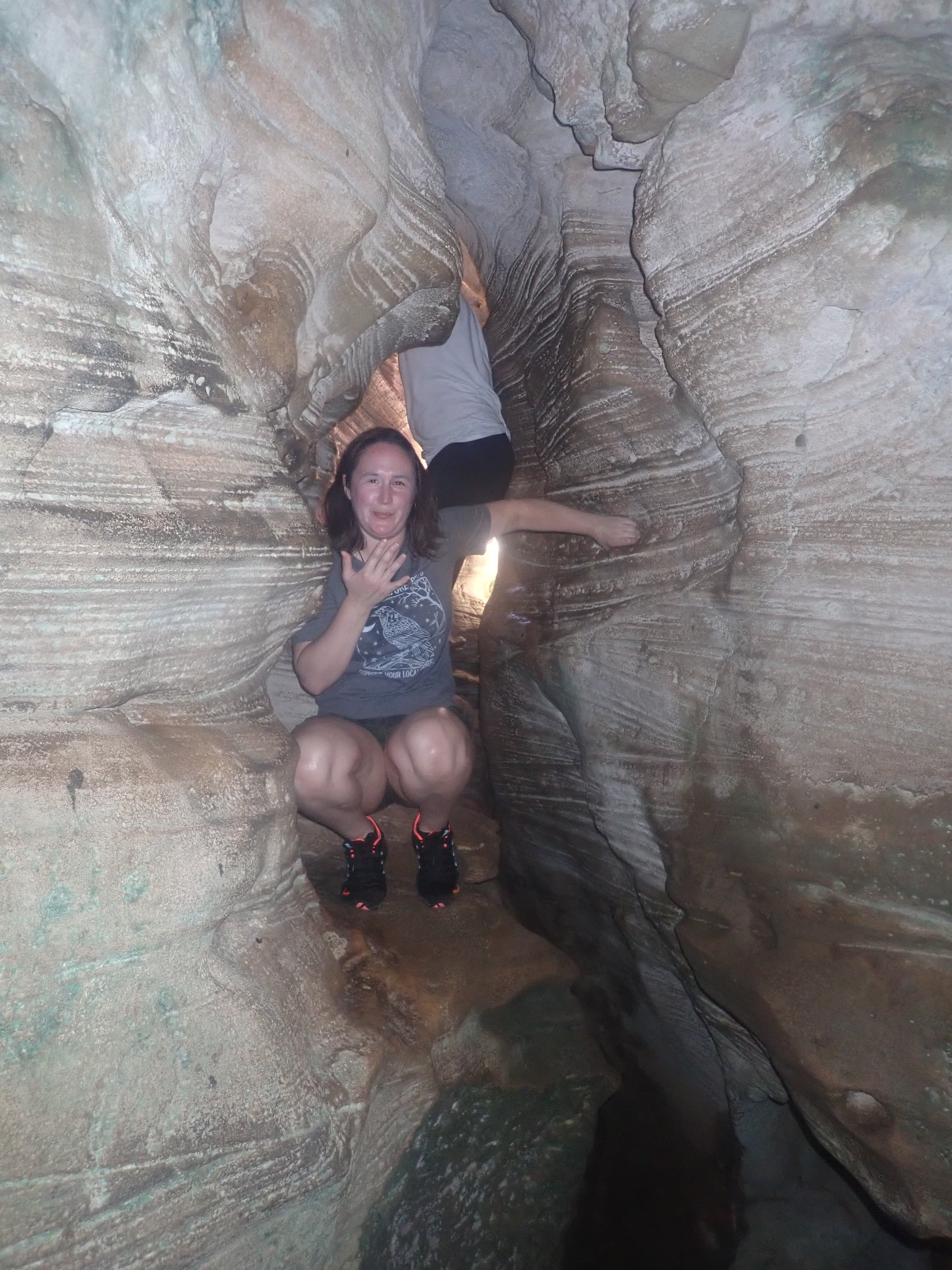 Hiker sitting inside a carved limestone cave
