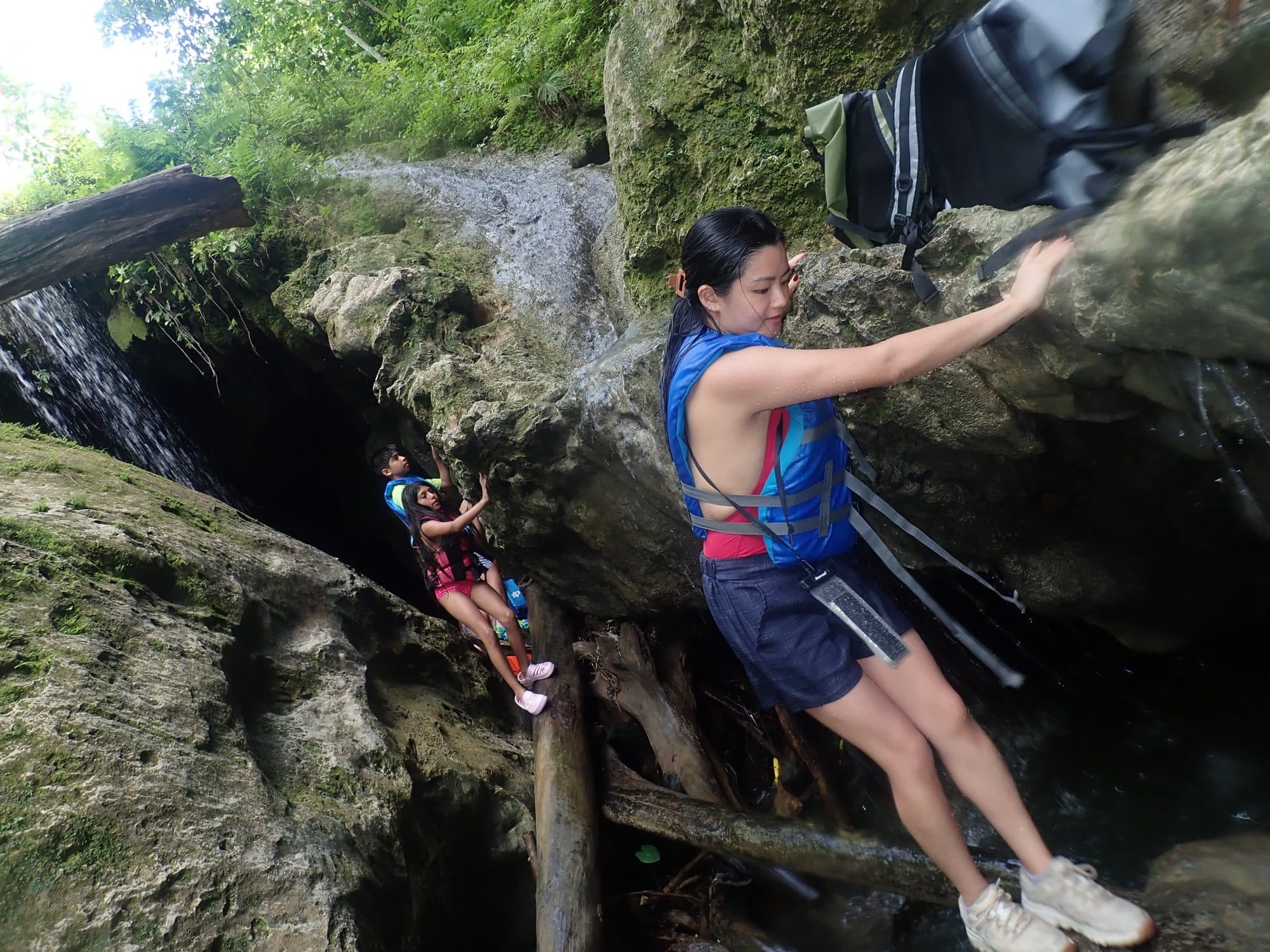 Guests climbing the rocks beside a waterfall