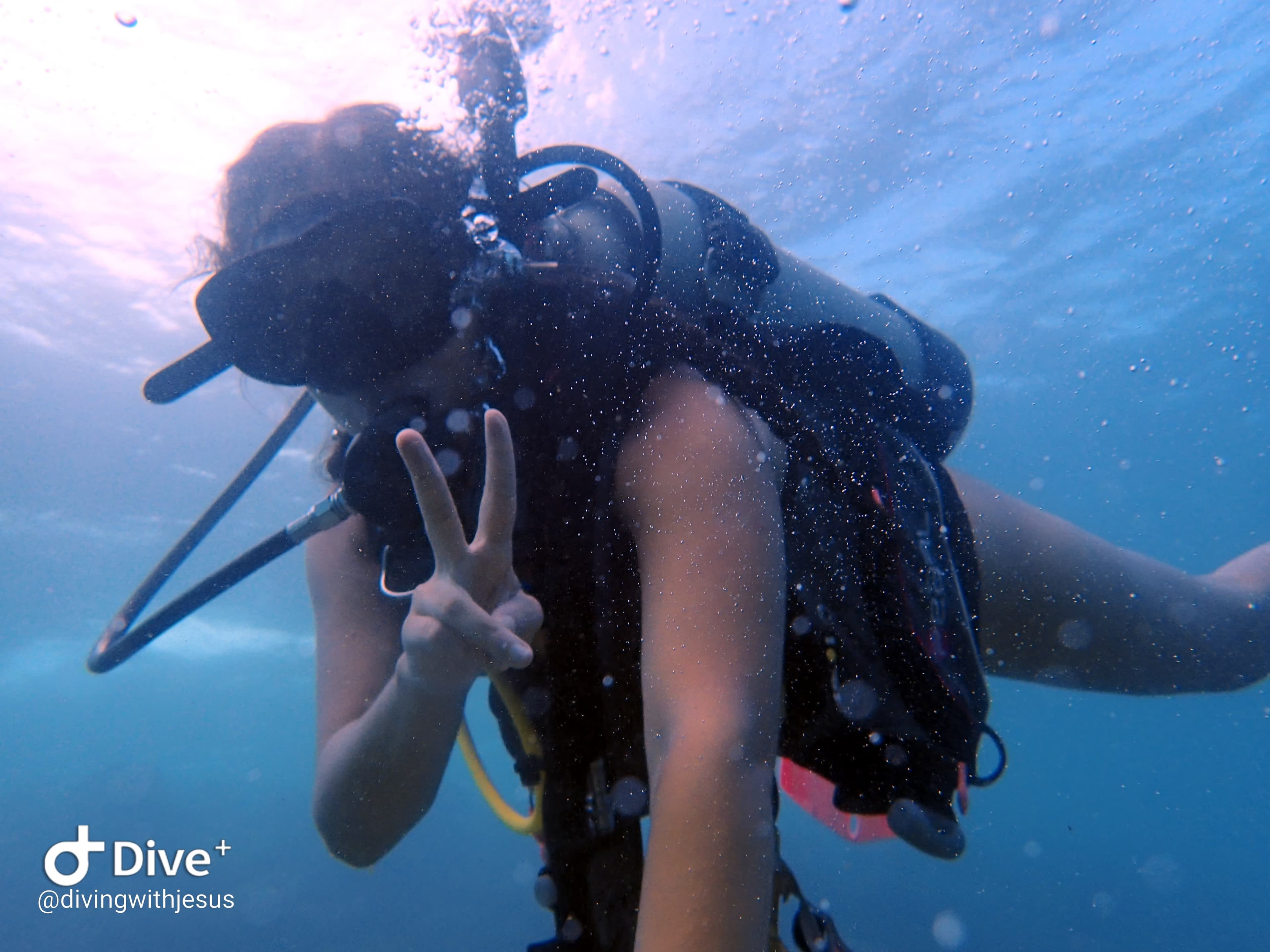 Scuba diver giving a peace sign underwater